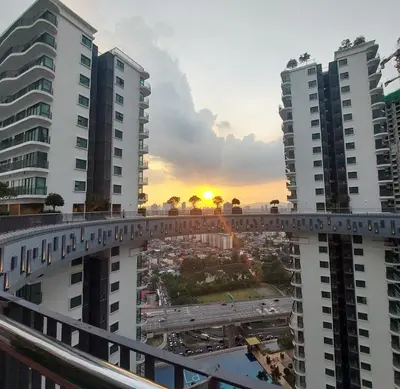 a bridge over a city with the sunset in the background at Datum Jelatek SKY Ring VIP Nice View in Kuala Lumpur