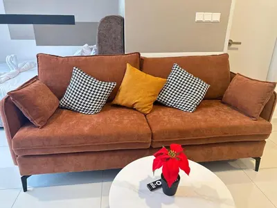a brown couch with pillows on top of a table at Private Family suite 23A13A1BR at KLCC in Kuala Lumpur