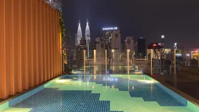 a swimming pool on top of a building with a city skyline at Cozy Couple studio 307B at KLCC in Kuala Lumpur