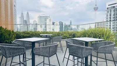 a group of tables and chairs on a patio with a city skyline at KLCC view couple suite 277B at KLCC in Kuala Lumpur