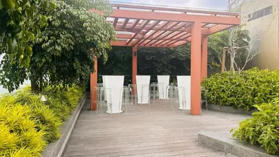 a pavilion with chairs and tables in a garden at KLCC view couple suite 277B at KLCC in Kuala Lumpur