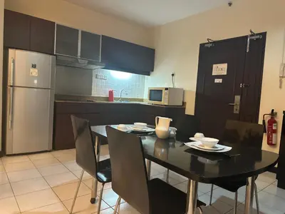 a kitchen with a black table and chairs and a refrigerator at Seri Bukit Ceylon Bukit Bintang Kuala Lumpur City Centre in Kuala Lumpur