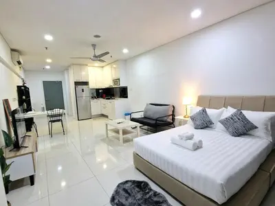 a bedroom with a bed and a living room at Mercu Summer Suites KLCC By ATIQ in Kuala Lumpur