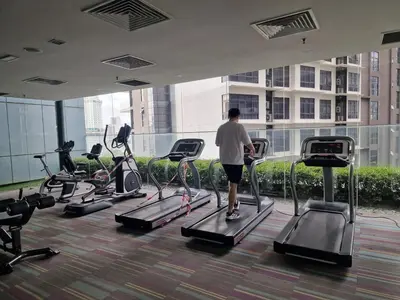 a man walking on a treadmill in a gym at Mercu Summer Suites KLCC By ATIQ in Kuala Lumpur