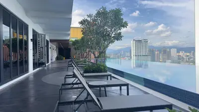 a building with a pool with tables and benches on it at Cozy couple suite 232B at Majestic Residence in Kuala Lumpur