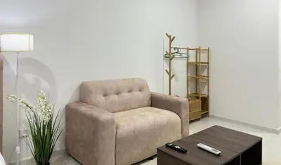a living room with a chair and a coffee table at Cozy couple suite 232B at Majestic Residence in Kuala Lumpur