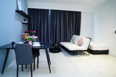 a living room with a table and a chair at Bukit Bintang Robertson Residences, KLCC in Kuala Lumpur