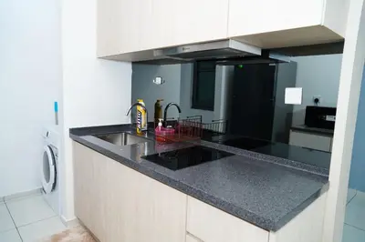 a kitchen with a sink and a black counter top at Bukit Bintang Robertson Residences, KLCC in Kuala Lumpur