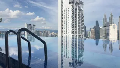 a swimming pool with a tall building in a city at KLCC view couple stay 276A at KLCC in Kuala Lumpur