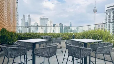 a patio with tables and chairs and a city skyline at Luxury private family suite 26161BR at KLCC in Kuala Lumpur