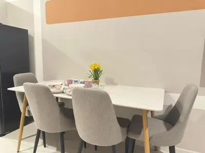 a dining room table with chairs and a white table at KLCC view studio suite 272B at KLCC in Kuala Lumpur