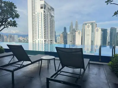 two chairs and a table on a balcony with a city at KLCC view studio suite 272B at KLCC in Kuala Lumpur
