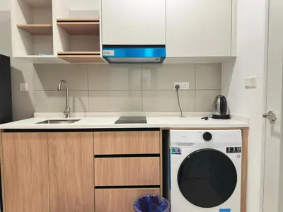 a kitchen with a washing machine under a counter at Luxury couple suite 295A at KLCC in Kuala Lumpur