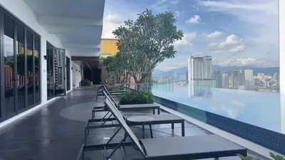 a swimming pool with tables and chairs on a building at KLCC view couple suite 293B at KLCC in Kuala Lumpur