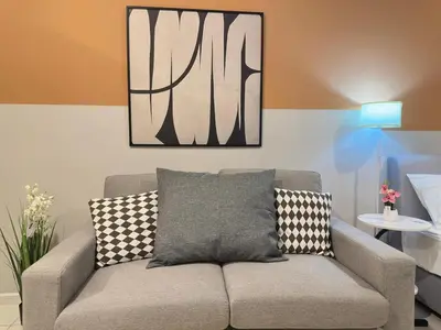 a couch in a living room with a picture on the wall at Cozy suite for couple 297A at KLCC in Kuala Lumpur