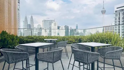 a patio with tables and chairs and a city skyline at Private family suite 27171BR at KLCC in Kuala Lumpur