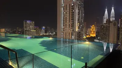 a large swimming pool on top of a building at night at Cozy KLCC view suite 305B at KLCC in Kuala Lumpur