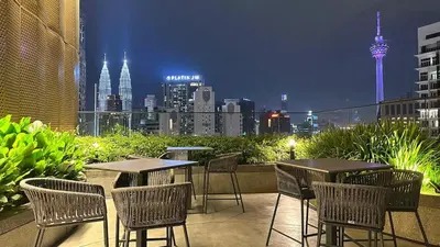 a patio with tables and chairs with a view of the city at KLCC view suite 292B at Majestic residence in Kuala Lumpur