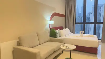 a living room with a couch and a bed and a window at KLCC view suite 292B at Majestic residence in Kuala Lumpur