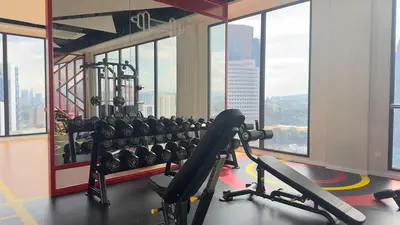 a gym with a bunch of machines and windows at Couple luxury suite 275B at Majestic Residence in Kuala Lumpur