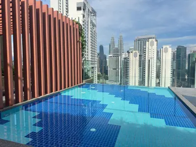 a large swimming pool on the roof of a building at Private family suite 23171BR at Majestic Residence in Kuala Lumpur