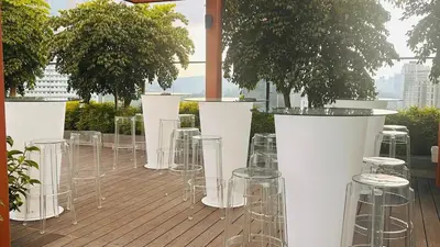 a row of chairs and tables on a deck with trees at Private family suite 23171BR at Majestic Residence in Kuala Lumpur