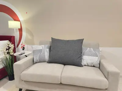 a couch with a gray pillow on top of it at Klcc view Luxe suite 295B at Majestic Residence in Kuala Lumpur