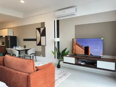 a living room with a couch and a flat screen tv at Private family suite 29201BR at Majestic Residence in Kuala Lumpur
