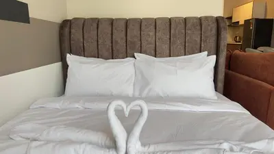 two swans made out of towels on a bed at Private family service suite 2613A1BR at Majestic Residence in Kuala Lumpur