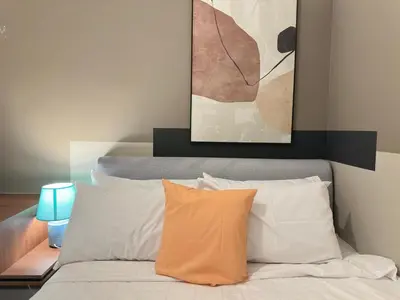 a bed with two pillows and a painting above it at Private family service suite 2613A1BR at Majestic Residence in Kuala Lumpur