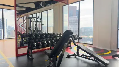 a gym with a lot of exercise equipment and windows at Cozy suite for couple 275A at Majestic Residence in Kuala Lumpur