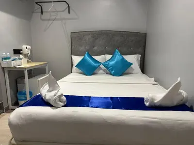 a bedroom with a bed with blue and white pillows at SS GREY INN Bb in Kuala Lumpur