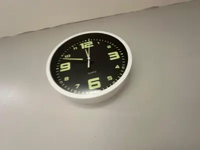 a clock is hanging on a wall at SS GREY INN Bb in Kuala Lumpur