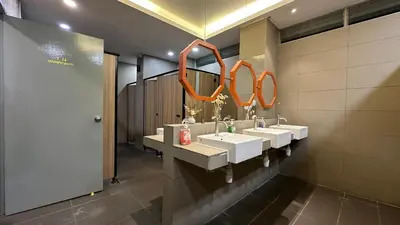a bathroom with three sinks and two mirrors at Traveller Ark Hotel and Bunks in Kuala Lumpur