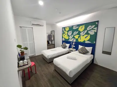 a bedroom with two beds and a painting on the wall at Traveller Ark Hotel and Bunks in Kuala Lumpur
