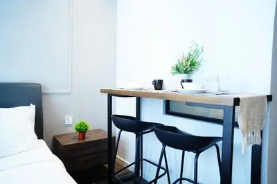 a table in a room with two chairs next to a bed at Scarletz Suites By Home Stay in Kuala Lumpur