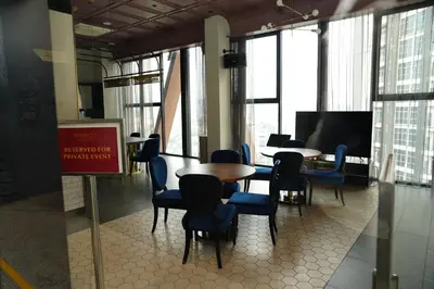 a dining room with tables and chairs and windows at Scarletz Suites By Home Stay in Kuala Lumpur