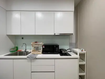 a kitchen with white cabinets and a microwave at Sentral Suites KL Sentral Kuala Lumpur by Nestaway in Kuala Lumpur