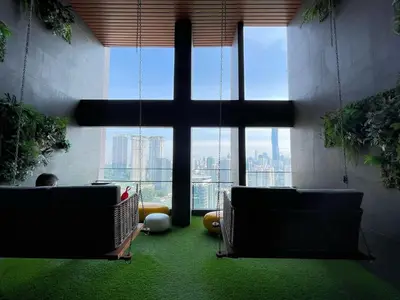 a man sitting in a chair in a room with a cross at The Riv Riveria City KL Sentral Kuala Lumpur by Nestaway in Kuala Lumpur