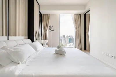 a white bed with a towel on top of it at Romantic Home in KLCC in Kuala Lumpur