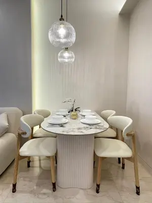 a dining room table with white chairs and a chandelier at Romantic Home in KLCC in Kuala Lumpur