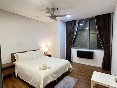 a bedroom with a white bed and a television at Mercu summer suites klcc luxury couple 1BR apartment with balcony, pool view free Netflix in Kuala Lumpur