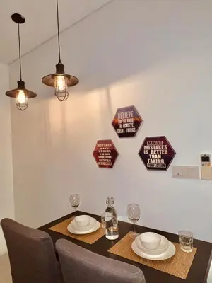 a dining room table with chairs and signs on the wall at Mercu summer suites klcc luxury couple 1BR apartment with balcony, pool view free Netflix in Kuala Lumpur