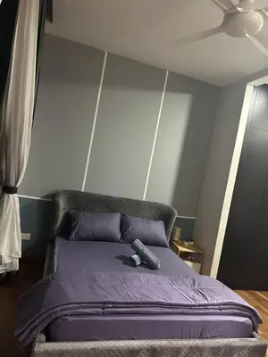 a bedroom with a purple bed with a ceiling fan at KL Gateway Premium Service Residence At University malaya in Kuala Lumpur