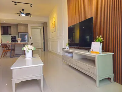 a living room with a television and a table with flowers at Cozy Velocity Residence2 Linked to Mall 6pax Wifi 600mbps in Kuala Lumpur