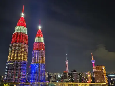 a group of tall skyscrapers lit up at night at Star residence KLCC by J&K in Kuala Lumpur