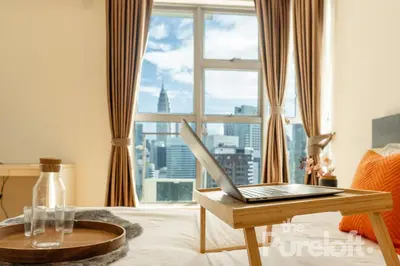 a room with a laptop on a table in front of a window at Suasana by TPL - Bukit Bintang KLCC in Kuala Lumpur