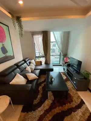 a living room with a black leather couch and a television at Casa Residency in Kuala Lumpur