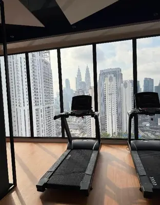 two exercise bikes in a room with a view of a city at Majestic Residence KLCC in Kuala Lumpur