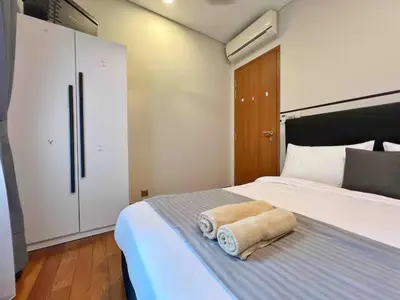 a bedroom with a bed with two towels on it at Nook Sky Suites KLCC in Kuala Lumpur